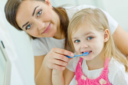 Mom and Daughter brushing their teeth - Pediatric Dentist in Hales Corners, WIists